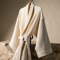 NUDA Organic Cotton Waffle Robe in soft ivory on natural stone